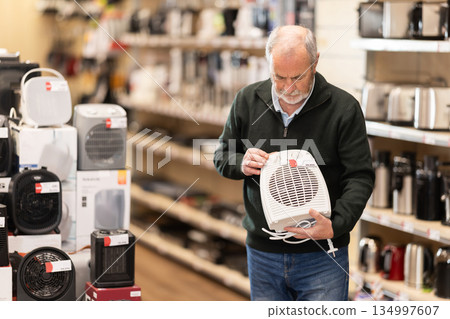 Elderly man choosing a portable heater 134997607