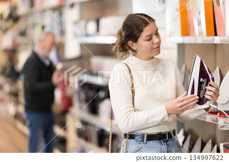 Woman choosing an iron in the store Woman choosing an iron in the store 134997622