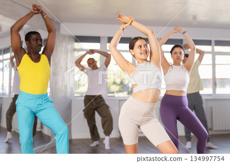 Young female fitness instructor leading upbeat Zumba class 134997754