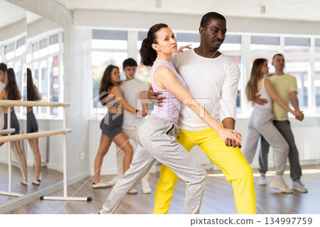 Group of women and men learning to dance latin dances in dance studio 134997759