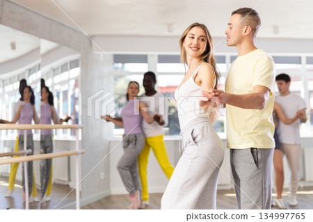 Young woman dances incendiary tango with man partner during choreography lesson 134997765