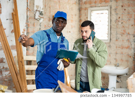 Builder signs documents from the engineer, pointing him to something 134997785