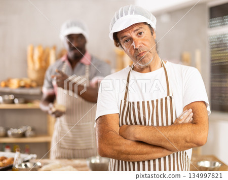 Two male bakers quarreling in workshop 134997821