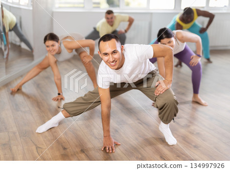 European guy with team of like-minded multinational people learn to elements of hip hop dance 134997926