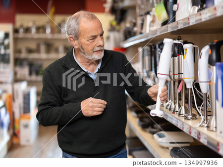 Elderly man choosing a blender in a store 134997936