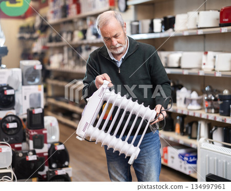 Elderly man choosing a portable heater 134997961