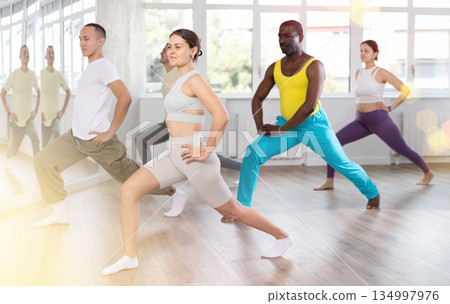Young woman doing leg exercises in training hall Young woman doing leg exercises in training hall 134997976