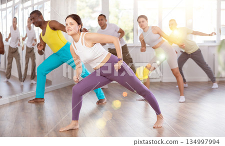 Young Asian woman practicing vigorous zumba with group 134997994
