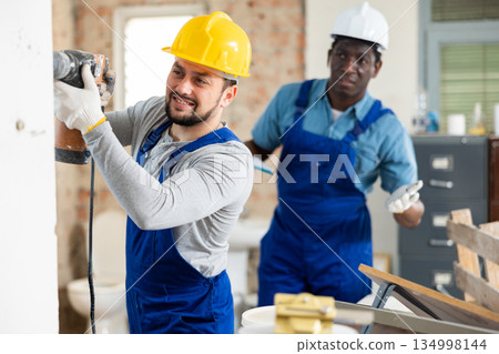 Man construction worker using demolition hammer in apartment 134998144