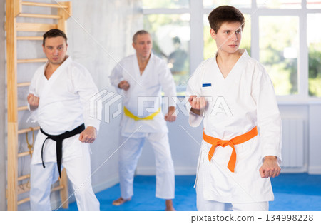 Young guy trains karate techniques in studio Young guy trains karate techniques in studio 134998228