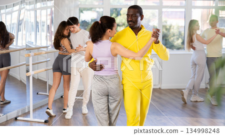 Middle-aged man and woman practicing waltz dance in pair in training hall 134998248