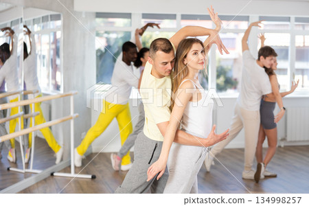 Man and young woman dancing waltz in couple during lesson at studio 134998257