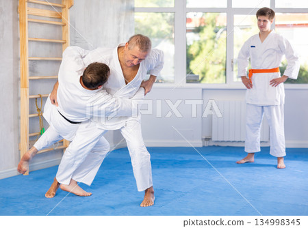 Adult and elderly men training judo fight 134998345