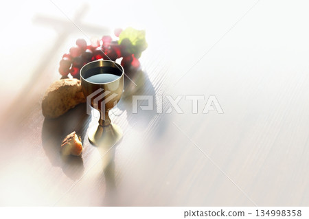 Bread and wine symbolizing the blood and body of Jesus Christ, the Holy Cross, and the background of the Eucharist 134998358