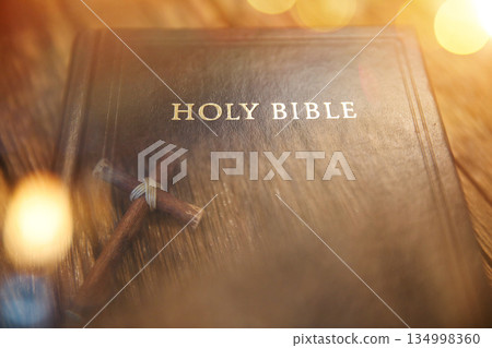Overlapping the Holy Bible and the cross of Jesus Christ, symbolizing his death and resurrection 134998360