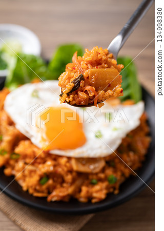 Korean kimchi fried rice with fried egg eating by spoon 134998380