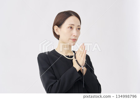 Woman in mourning clothes praying white background Woman in mourning clothes praying white background 134998796