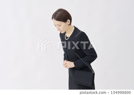 Woman in mourning clothes bowing white background 134998800