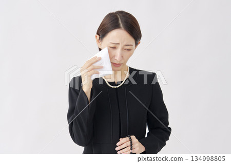 Woman in mourning clothes crying white background 134998805