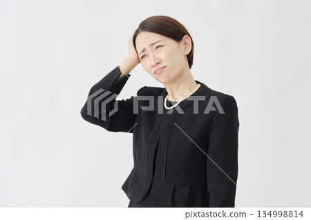 身著喪服的女子抱頭，白色背景 134998814