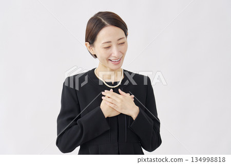 A woman in mourning clothes stroking her chest, white background A woman in mourning clothes stroking her chest, white background 134998818