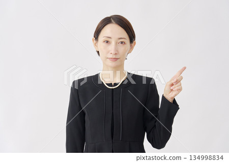 Woman in mourning clothes pointing to the right, white background 134998834