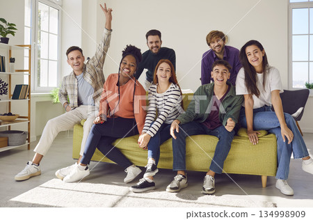 Portrait of smiling group of diverse multiracial young people sitting on sofa. 134998909