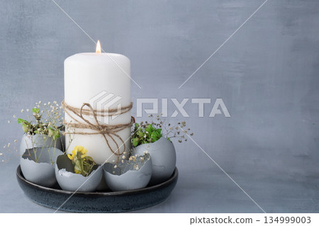 Creative handmade Easter table decoration with egg shells instruction candle on grey background. Easter home decoration. Copy space greeting card Seasonal sustainable recycled 134999003