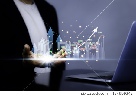 Business investment growth concept with rising stock chart, arrows and businessman holding digital financial graph Business investment growth concept with rising stock chart, arrows and businessman holding digital financial graph 134999342