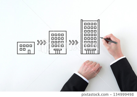 A businessman's hand drawing an image of how to greatly develop a company A businessman's hand drawing an image of how to greatly develop a company 134999498