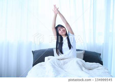 Stretching your arms in bed Stretching your arms in bed 134999545