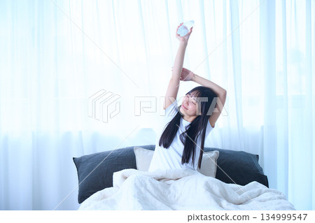 Stretching your arms in bed Stretching your arms in bed 134999547