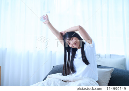 Stretching your arms in bed 134999549