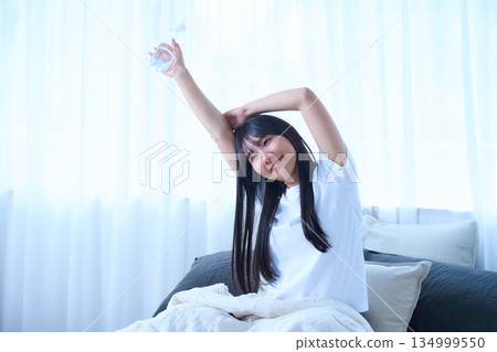 Stretching your arms in bed 134999550