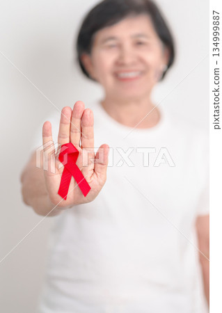 Elderly with Red Ribbon for December World Aids Day, MADD, October Red ribbon week, February Heart month, Marfan Syndrome, May Stroke awareness, March world TB Tuberculosis day and April Dare day 134999887