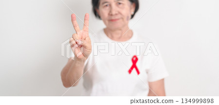 Elderly with Red Ribbon for December World Aids Day, MADD, October Red ribbon week, February Heart month, Marfan Syndrome, May Stroke awareness, March world TB Tuberculosis day and April Dare day 134999898