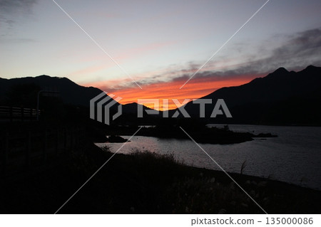 秋日的夕陽灑在河口湖上，湖面平靜如鏡。 135000086