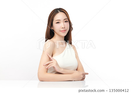 A beautiful young Asian woman with clean, fresh skin against a white background. Skincare, facial treatment, cosmetology, beauty, and spa. An elegant portrait of an Asian woman. 135000412