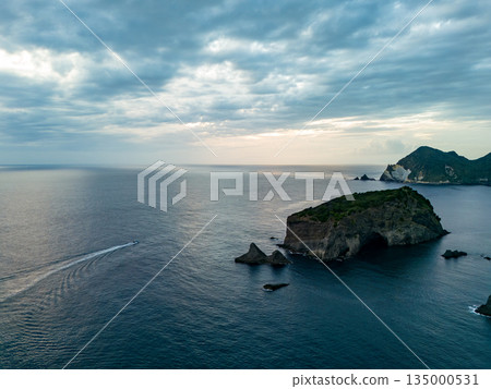 Drone shot of the waters off Hirizohama at dusk. A fishing boat is sailing on a sunset cruise. Hirizohama, Nakagi, Minamiizu Town 135000531
