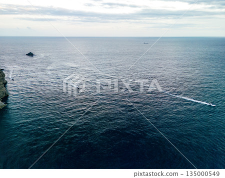 Drone shot of the waters off Hirizohama at dusk. A fishing boat is sailing on a sunset cruise. Hirizohama, Nakagi, Minamiizu Town 135000549
