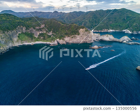 Drone shot of the waters off Hirizohama at dusk. A fishing boat is sailing on a sunset cruise. Hirizohama, Nakagi, Minamiizu Town 135000556