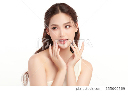 A beautiful young Asian woman with clean, fresh skin against a white background. Skincare, facial treatment, cosmetology, beauty, and spa. An elegant portrait of an Asian woman. A beautiful young Asian woman with clean, fresh skin against a white background. Skincare, facial treatment, cosmetology, beauty, and spa. An elegant portrait of an Asian woman. 135000569