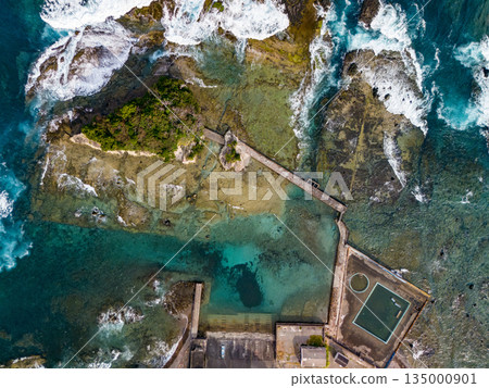 Ryugujima Island in Shimoda, Izu, and the red torii gate of Shirashima Shrine. Drone shot from Ogasaki Wing. Blue sea, white waves, and green forest. 135000901