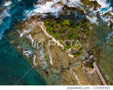 Ryugujima Island in Shimoda, Izu, and the red torii gate of Shirashima Shrine. Drone shot from Ogasaki Wing. Blue sea, white waves, and green forest. Ryugujima Island in Shimoda, Izu, and the red torii gate of Shirashima Shrine. Drone shot from Ogasaki Wing. Blue sea, white waves, and green forest. 135000902