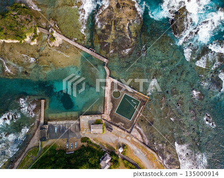 Ryugujima Island in Shimoda, Izu, and the red torii gate of Shirashima Shrine. Drone shot from Ogasaki Wing. Blue sea, white waves, and green forest. Ryugujima Island in Shimoda, Izu, and the red torii gate of Shirashima Shrine. Drone shot from Ogasaki Wing. Blue sea, white waves, and green forest. 135000914