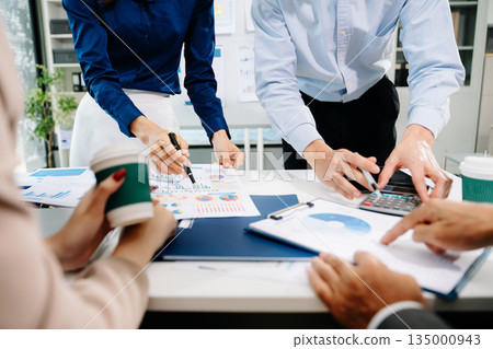 Businessman and team analyzing financial statement Finance task. with smart phone and laptop and tablet. 135000943