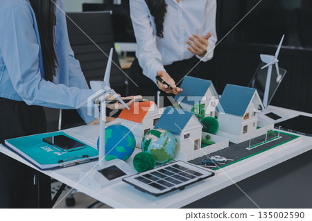 Hands of adult Asian business professionals analyzing ESG financial data and renewable energy project plans 135002590