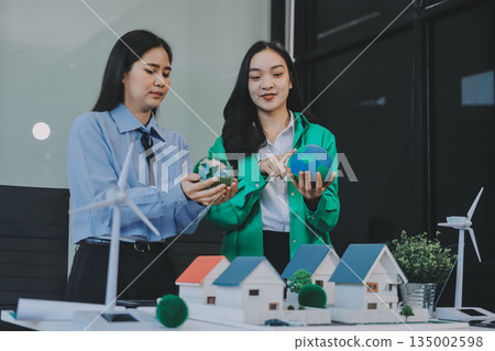 Hands of adult Asian business professionals analyzing ESG financial data and renewable energy project plans Hands of adult Asian business professionals analyzing ESG financial data and renewable energy project plans 135002598