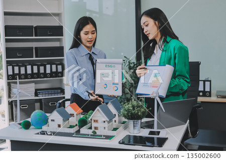 Hands of adult Asian business professionals analyzing ESG financial data and renewable energy project plans Hands of adult Asian business professionals analyzing ESG financial data and renewable energy project plans 135002600