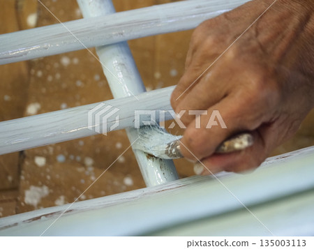 Hand paintbrush painting furniture renovation closeup repair wood indoor detail hand paintbrush painting furniture renovation Hand paintbrush painting furniture renovation closeup repair wood indoor detail hand paintbrush painting furniture renovation 135003113